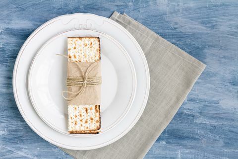 balta lėkštė su matza arba matza ant vintažinio stalo fono pristatoma kaip Paschos seder šventė ar valgis