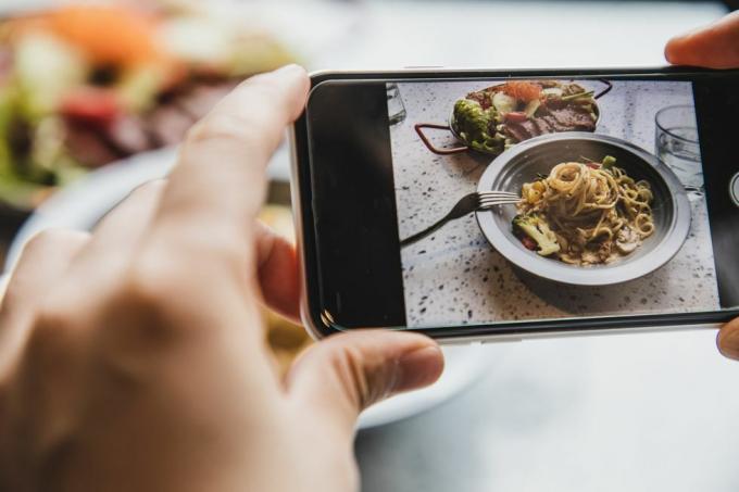 asmeninė perspektyva naudojant telefoną fotografuojant kreminius šoninės spagečius ir salotas