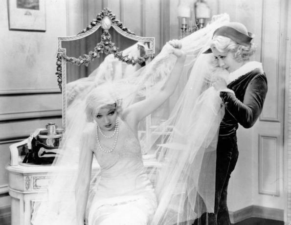 amerikiečių komiksų aktorė Joan Blondell 1909 m. 1979 m. kovoja su sudėtingu vestuvinės suknelės šydu scenoje iš nežinomos filmo nuotraukos, kurią sukūrė Hulton Archivegetty images