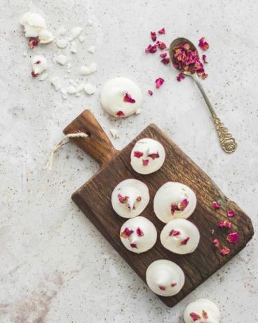 rožėmis klostyti meringue sausainiai ant stalo