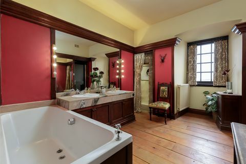 Didelis šeimos vonios kambarys su raudonomis sienomis 