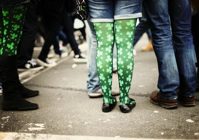 Švento Patriko dienos parado nuotrauka, kurioje daugiausia dėmesio skiriama moters žaliais dobilais margintos pėdkelnės, derinamos su džinsinio audinio kirpimais, galite parašyti „šiandien taps žalia“