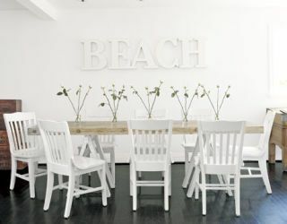 neoficialus valgomasis su sulankstomomis kėdėmis ir paplūdimiu baltomis raidėmis ant sienos
