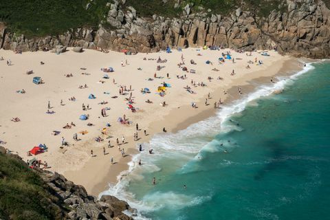 Žmonės mėgaujasi geru oru Porthcurno paplūdimyje netoli Penzance 