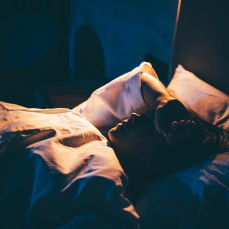 moteris su nemiga jauna moteris guli ant lovos su ranka ant kaktos
