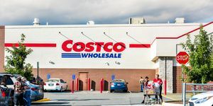 Fairfax žmonės su pirkinių krepšeliais, užpildytais bakalėjos prekėmis, produktais, išeinančiais iš Costco parduotuvės Virdžinijoje automobilių stovėjimo aikštelėje