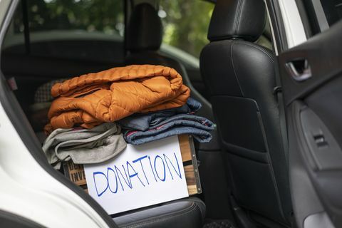 aukų dėžutė su drabužiais automobilyje